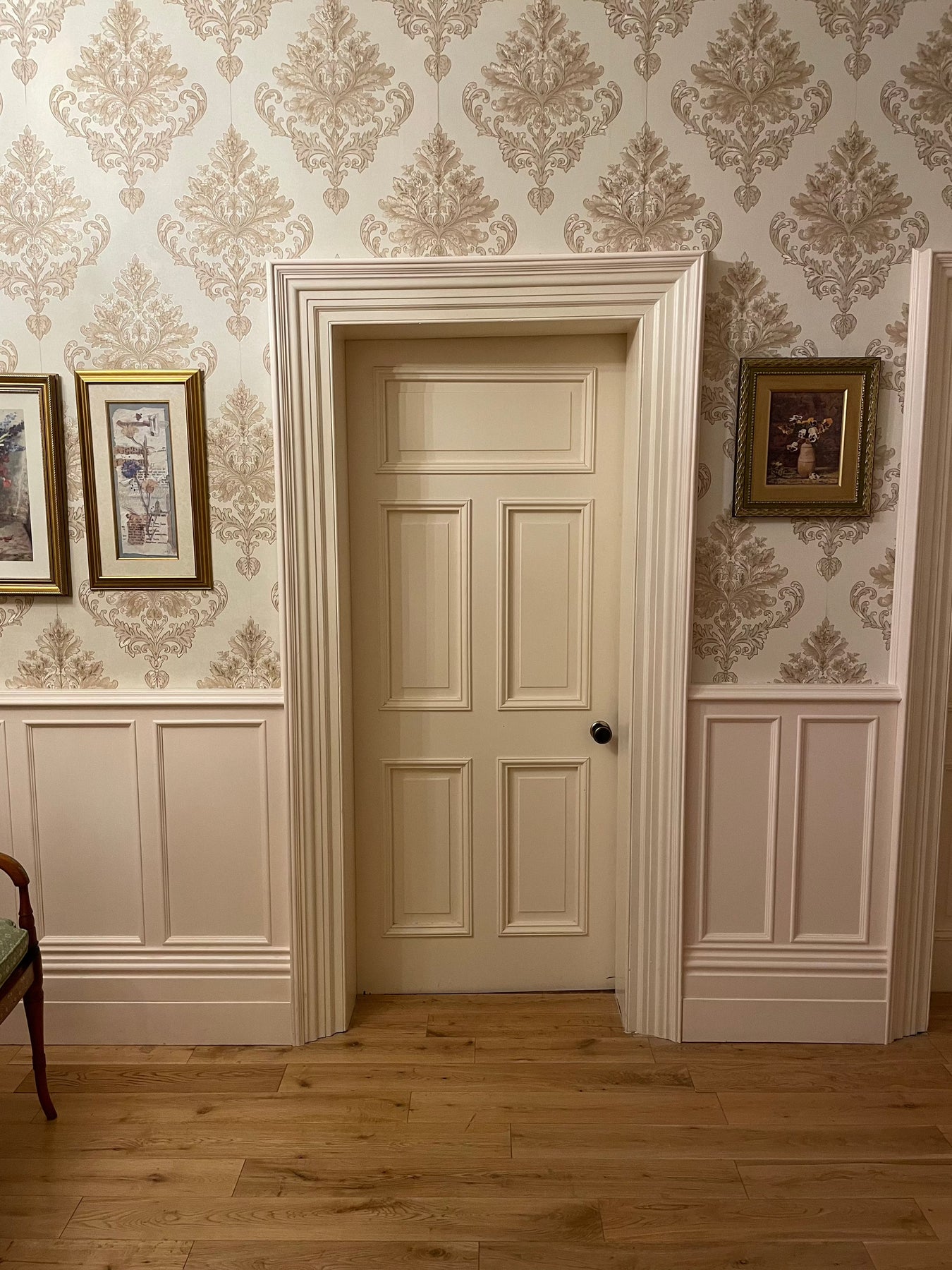 Intricately detailed architrave framing a four-panel doorset, adding elegance and charm to the space.