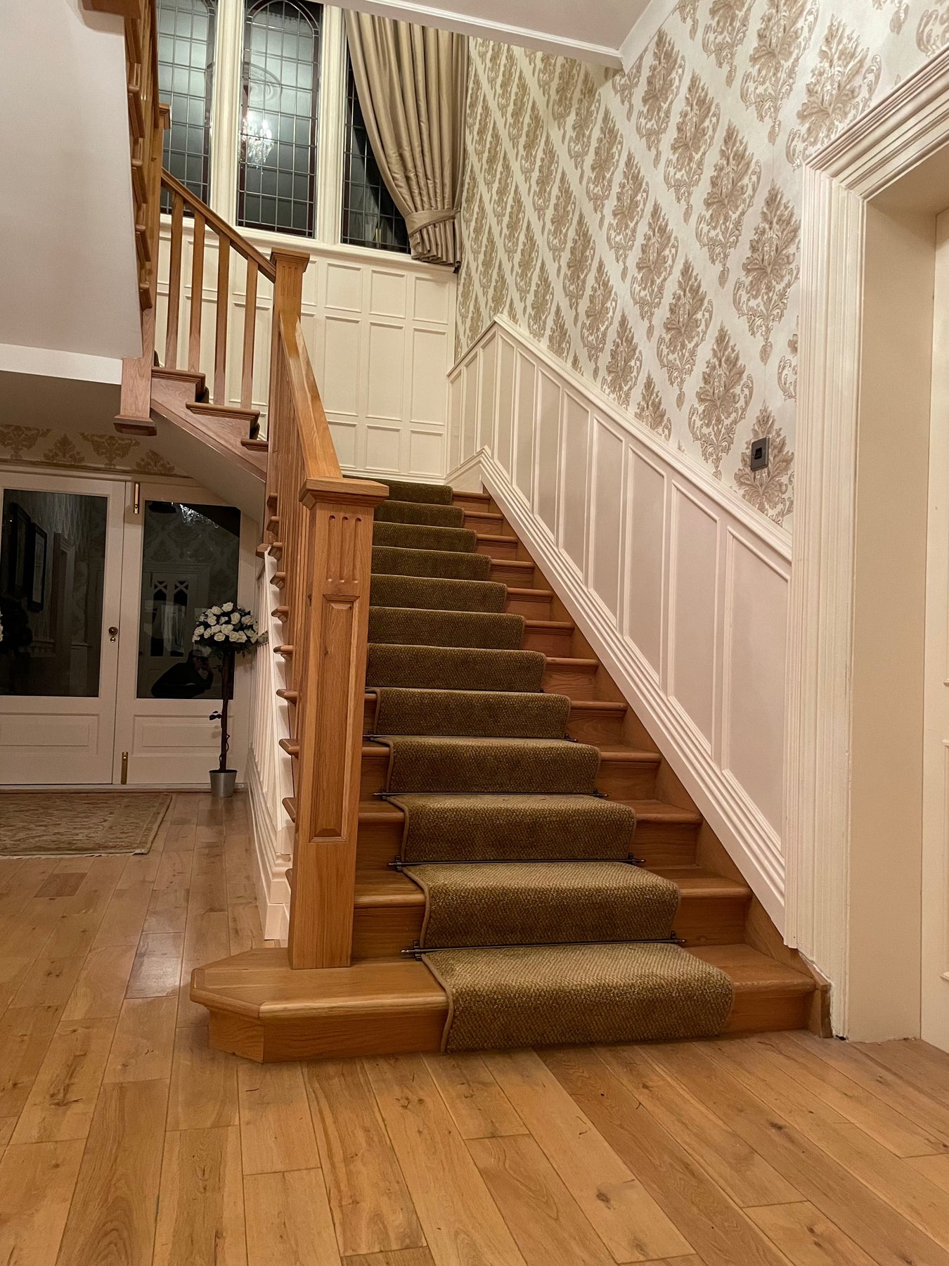 Stunning oak cut string staircase with ornate newel caps and decorative newels for timeless elegance.