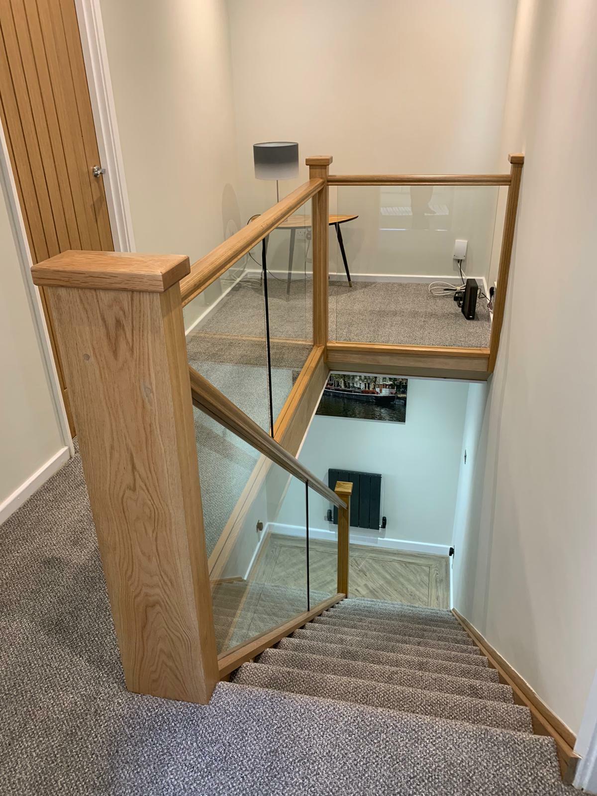 Oak staircase adorned with sleek handrails, baserails, and glass balustrades for a modern touch.
